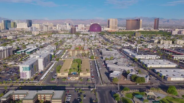 Aerial pullback shot of Las Vegas suburbs and Strip skyline and mountains 