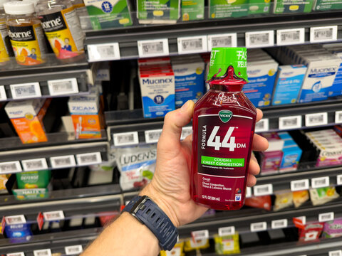 Vicks DayQuil 44D Cold and Flu Medicine Held in Pharmacy Aisle