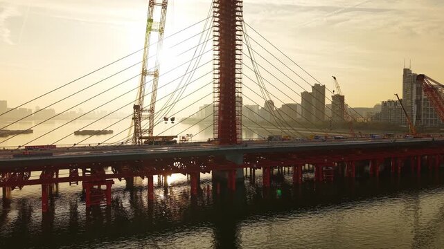 Aerial view of bridge sections being dismantled with a large crane over a river