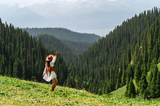 Young woman traveler relaxing and enjoying beautiful Scenery landscape with colorful flowers in Kalajun grassland of Xinjiang in summer