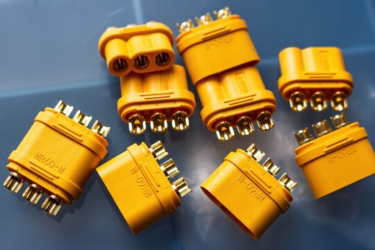 Close-up of yellow MR60 3-phase power connectors, featuring shiny gold-plated brass terminals. Robust electrical parts for motor connections