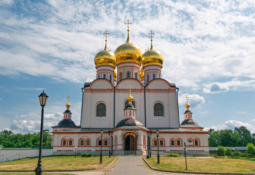 Majestic Assumption Cathedral at Valdai Iversky Monastery showcasing golden onion domes under a bright cloudy sky