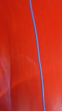 Vertical interior POV of man applying soapy foam to car window with sudsy brush during detailing