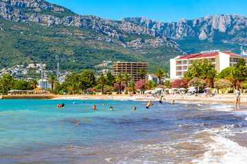 Bar Montenegro Beach tourists people water waves sun loungers parasols. © Arkadi