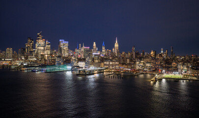 Fototapeta premium New York City at night. New York downtown skyline. NYC night cityscape with Manhattan. NYC landscape. New York panoramic. New York skyline. Lower Manhattan aerial view.