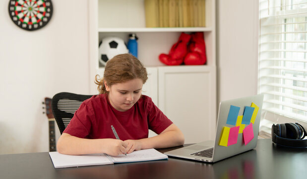 Child doing homework. Kid writing notes while studying with laptop. Writing student with pencil. Child doing schoolwork. Child student learning at home. School child studying. Cute kid doing homework.
