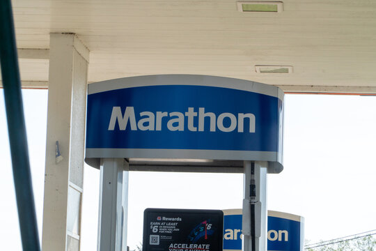 Marathon Gas Station sign featuring its prominent blue and white logo, highlighting the M Rewards program for fuel and convenience store savings at a busy roadside location.