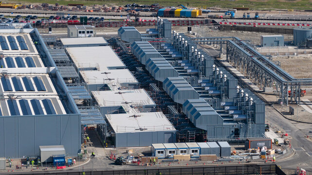 Aerial view of Datacenter Westpoort featuring industrial cooling systems and solar panels on the roof under bright daylight in Groningen, Groningen, Netherlands.