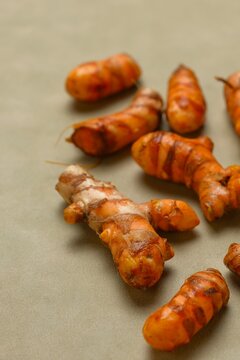 Fresh organic turmeric roots ((Curcuma longa) on brown background. Kunyit or kunir