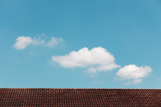 Clouds in the Blue Sky on Sunny Day over Red rooftop