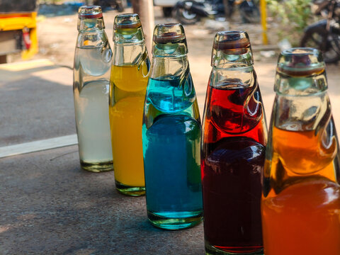 ​Colorful Goli Soda glass bottles lined up on a street stall