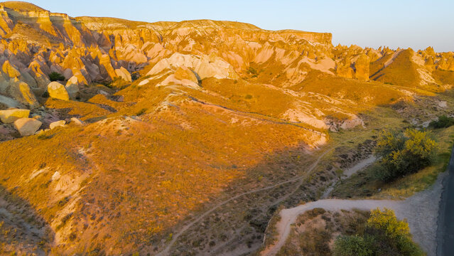 Goreme, Nevsehir, Turkey. Aerial view of Devrent Valley showcasing unique fairy chimney formations and colorful rock patterns during evening sunset.. Aerial View