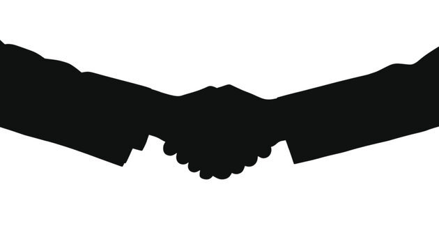 Handshake silhouette depicts two professional individuals connecting in a gesture of agreement, partnership, and successful business negotiation within a modern corporate office environment setting.