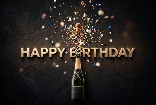 Elegant champagne bottle exploding with confetti and golden happy birthday words on dark wall