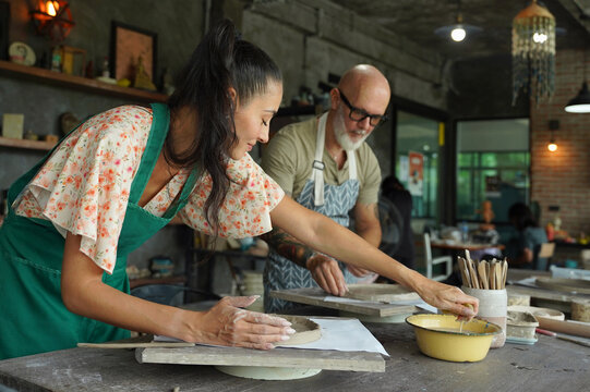 A happy couple makes ceramic plates in a workshop
