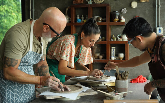 A happy couple makes ceramic plates in a workshop