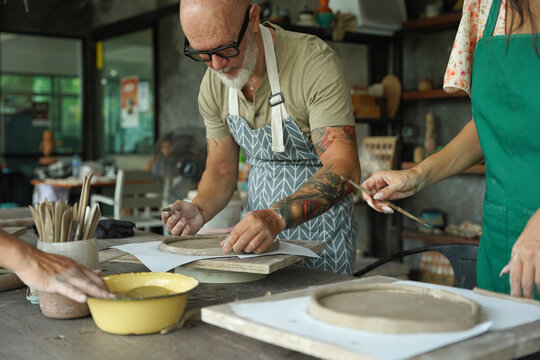 A happy couple makes ceramic plates in a workshop