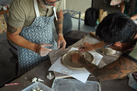 A happy couple makes ceramic plates in a workshop