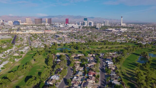 Aerial pullback drone shot of Las Vegas suburbs and city skyline and streets 