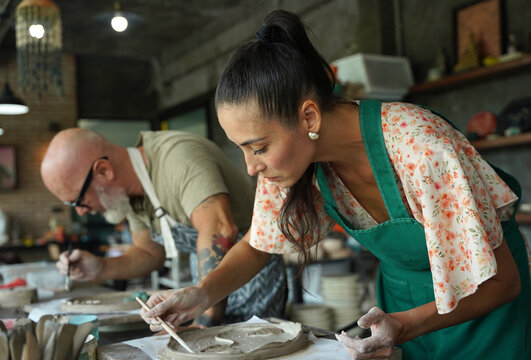 A happy couple makes ceramic plates in a workshop