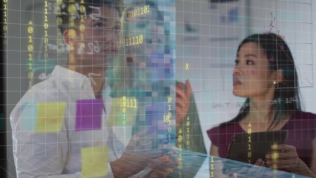 Team tapping tablet, placing sticky notes on clear grid glass, making data overlay for product plan