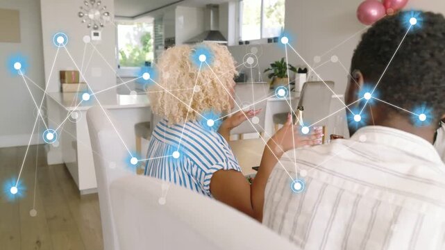 Curly woman clapping while camera panning, network overlay growing over dining table, showing tech