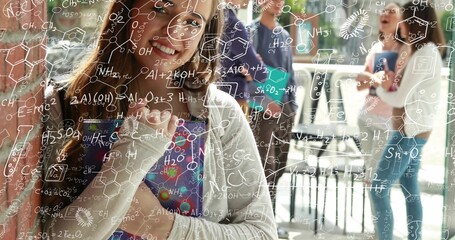 Fototapeta premium Smiling female student holding colorful notebook in campus lounge with chemistry overlay and phones