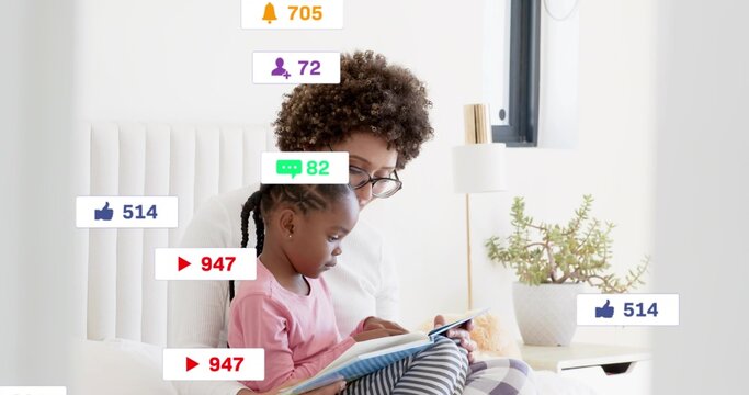 Reading woman wearing glasses holding child in pink top, sharing book on bed with social icons