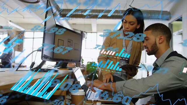 Standing woman pointing at laptop guiding seated man analyzing finance charts drifting over screen
