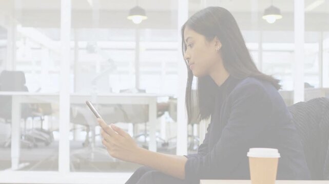 Post color bars clearing, woman sat on phone tapping, reading business messages, coffee cup visible