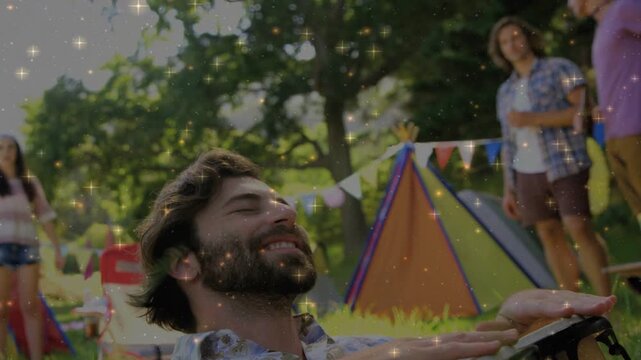 Bearded man after leaning back, tapping bongo and entertaining peers, causing sparkle music overlay