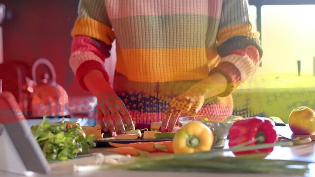 Cook following tablet recipe, prepping veg for cooking while animated dots overlaying hands and veg