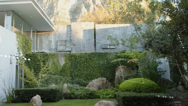 Overlays drifting across clear pane, camera rising, tilting, garden still, cliff revealing AR view