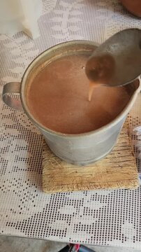 Stirring Red Corn Pinole Atole in a Small Pot