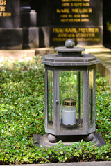 schönes Grablicht mit einer weißen Kerze auf einem Friedhof in Köln © Blende8