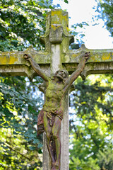 sehr altes Steinkreuz mit dem Heiland  auf einem Friedhof in Köln © Blende8