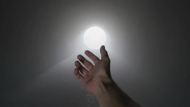 Hand reaching toward a radiant light, symbolizing hope, guidance, and the promise of a brighter future
