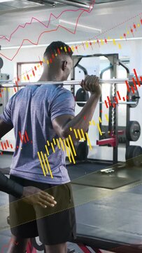 Vertical video: Pro spotting client bracing bar while adjusting for safety in gym red or yellow char