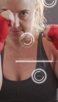 Vertical video: Female boxer jabbing with red hand wraps as camera zooms, HUD tracking fitness data