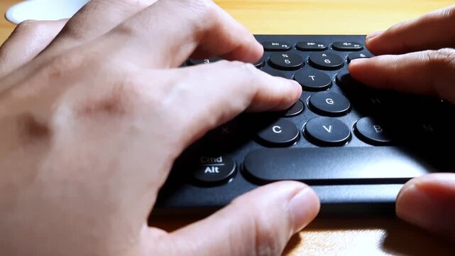 Close Up Of Hands Typing On Modern Black Wireless Keyboard With Round Keys