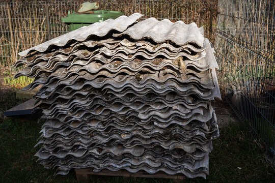 Close-up of dismantled old corrugated asbestos roof sheets, also known as eternit, on an old brick building.