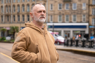 Man stands on busy street with buildings and cars behind him in the city © Iryna