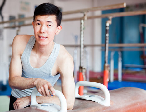 Male gymnast resting at pommel horse after training