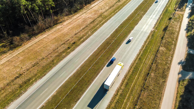 Cargo truck driving past green fields