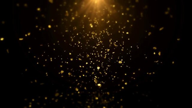 Slow motion static tilt zoom of gold particles falling and drifting under spotlight on black studio background