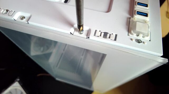 Removing a screw from the desktop chassis box.