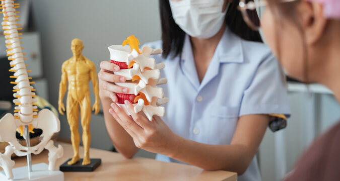 Medical healthcare diagnosis doctor patient consultation in clinic as specialist explaining spine model for back pain consultation and treatment plan during professional healthcare visit