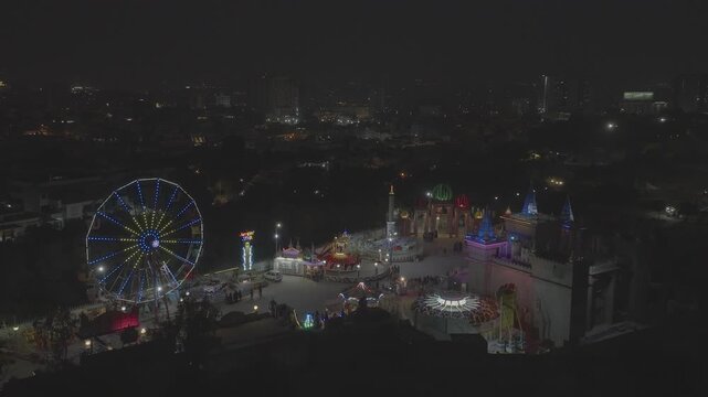 Lunapark in Pakistan nella citt&agrave; di Karachi ripreso dal drone di notte. Luci di giochi in movimento