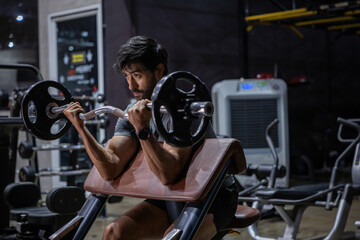 Fototapeta premium Weightlifting gym man bicep curl barbell strength training athlete workout fitness enthusiast performing preacher curl with barbell gym, focused expression, muscular arm, indoor training equipment