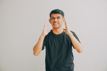 Fototapeta premium man showing frustration with hands up against plain background, studio lighting